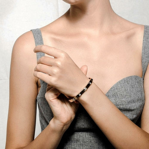 Person wearing a bracelet on a plain background