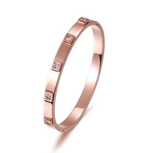 Rose gold bracelet with embedded diamonds on a white background